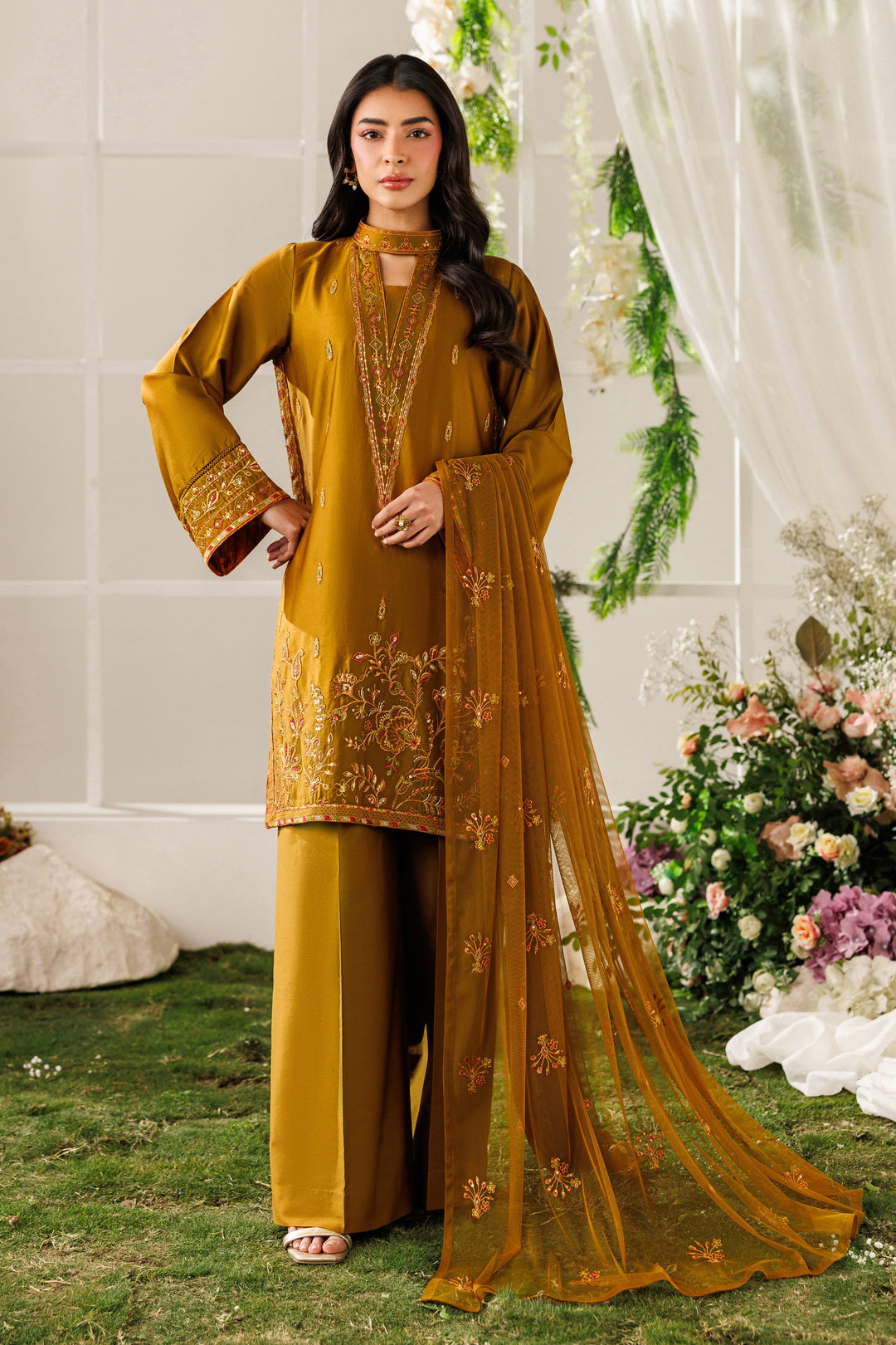 Front standing view of NAQSHI Eda outfit showing embroidered ban neck, golden brown tone, and balanced silhouette