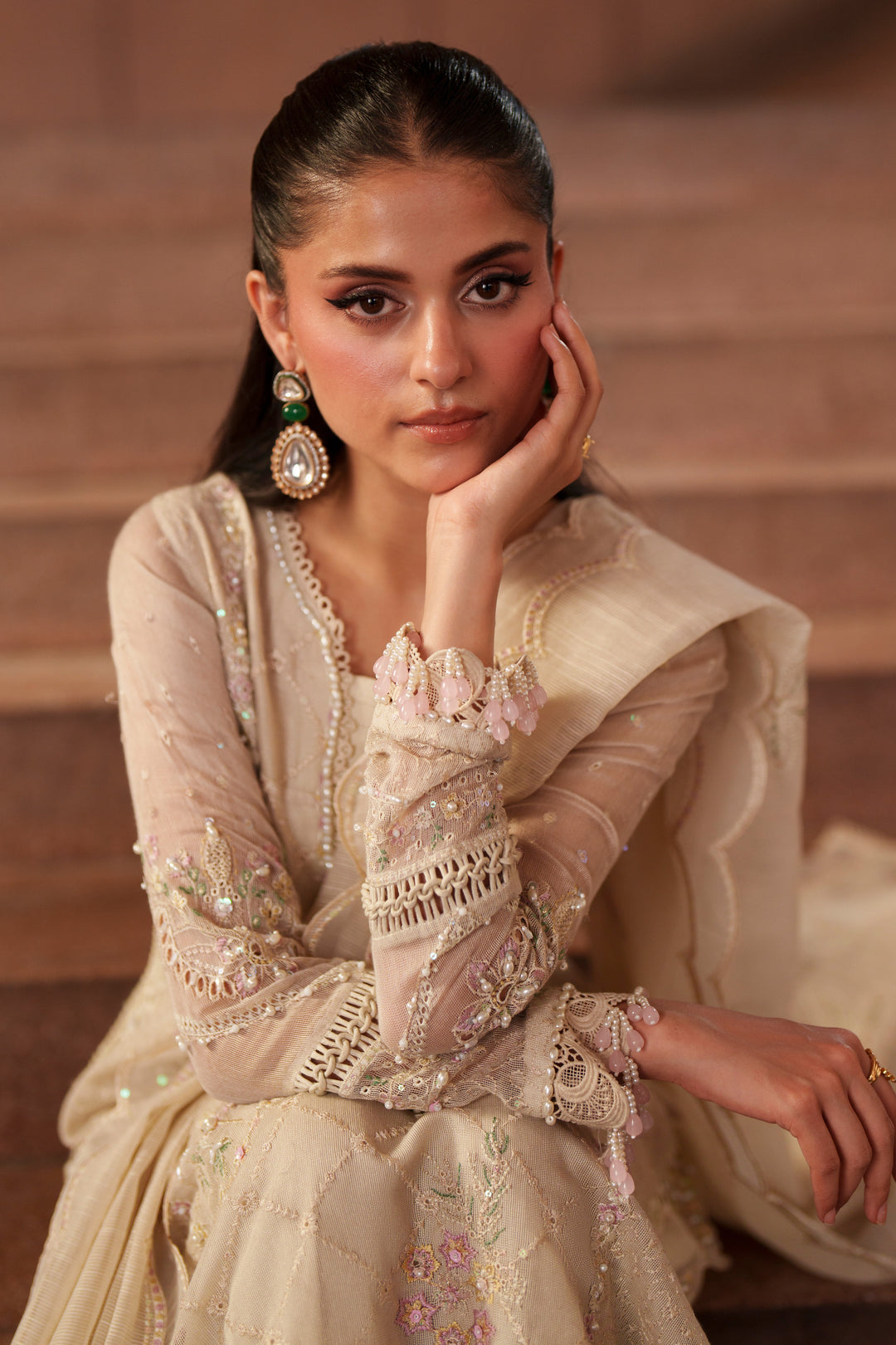 Portrait styling shot of Ingrid off-white evening wear outfit featuring embroidered sleeves, soft embellishments and sophisticated formal fashion