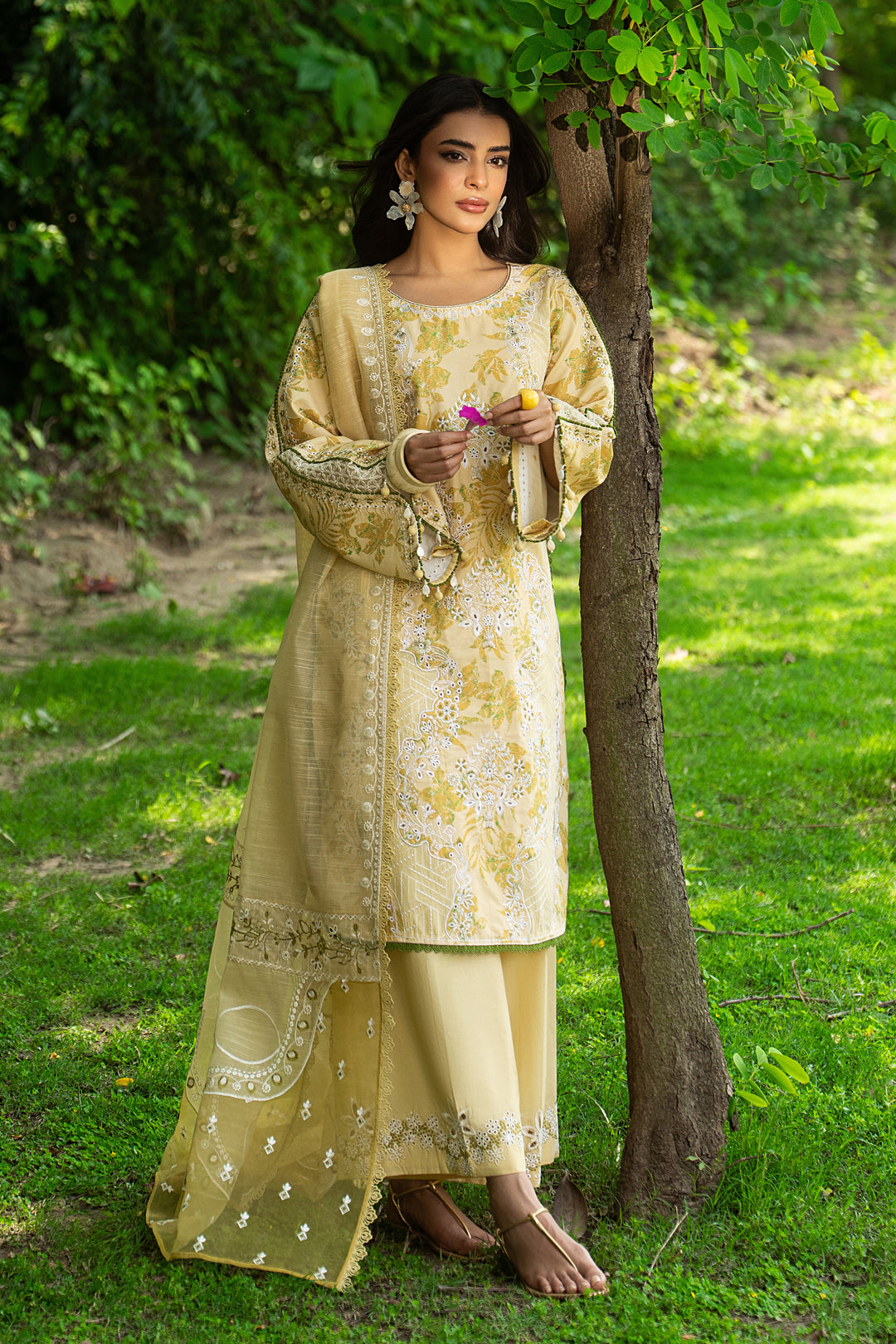 Side angle of Ashfi yellow lawn dress highlighting wide organza sleeves with lace finishing and soft embroidery details.