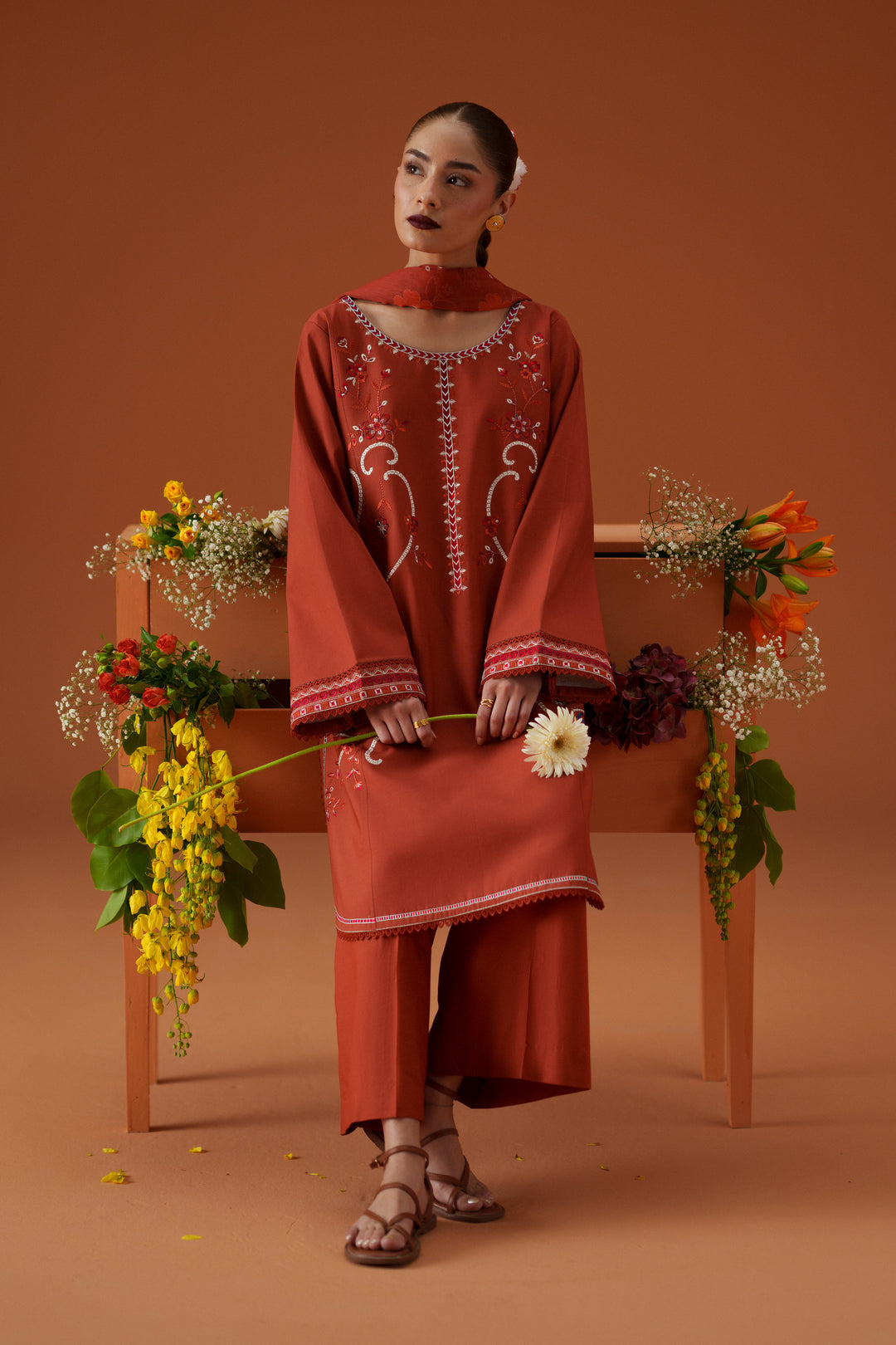 Ophelia rust casual pret outfit styled with floral setup, featuring embroidered lawn shirt, culotte trouser, and printed chiffon dupatta.