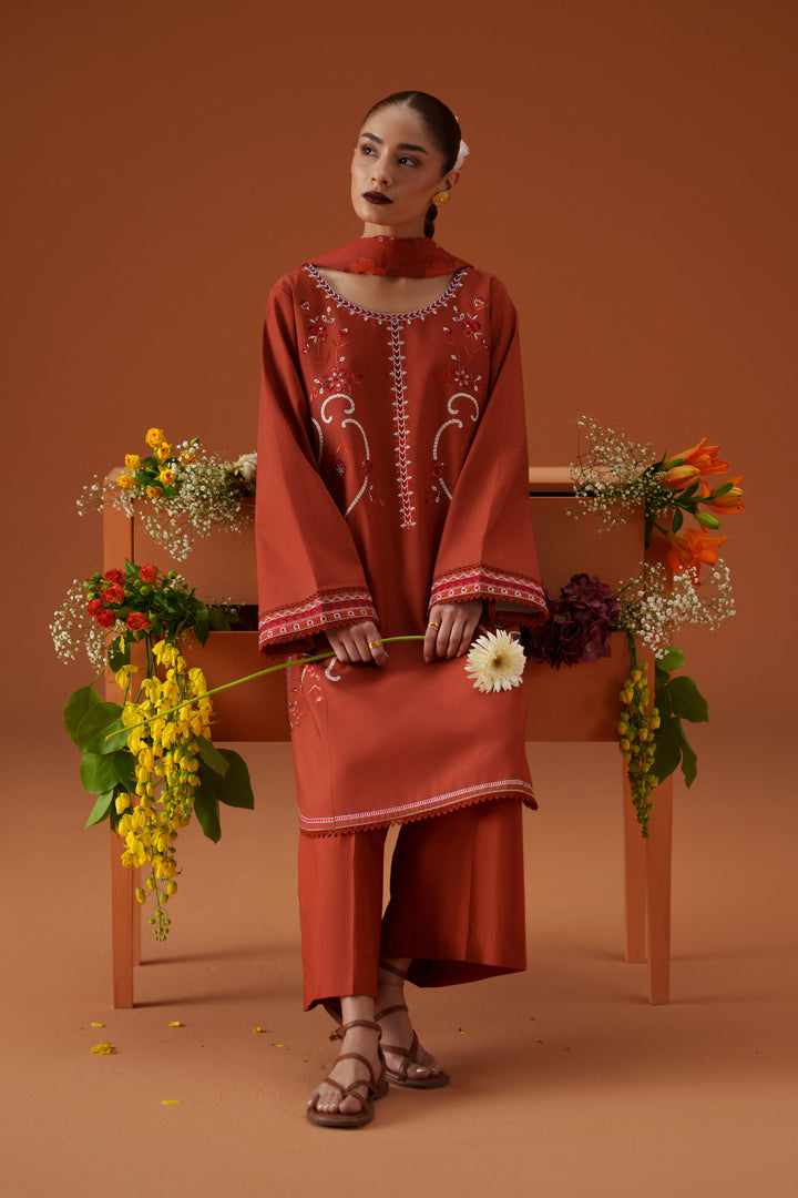 Ophelia rust casual pret outfit styled with floral setup, featuring embroidered lawn shirt, culotte trouser, and printed chiffon dupatta.