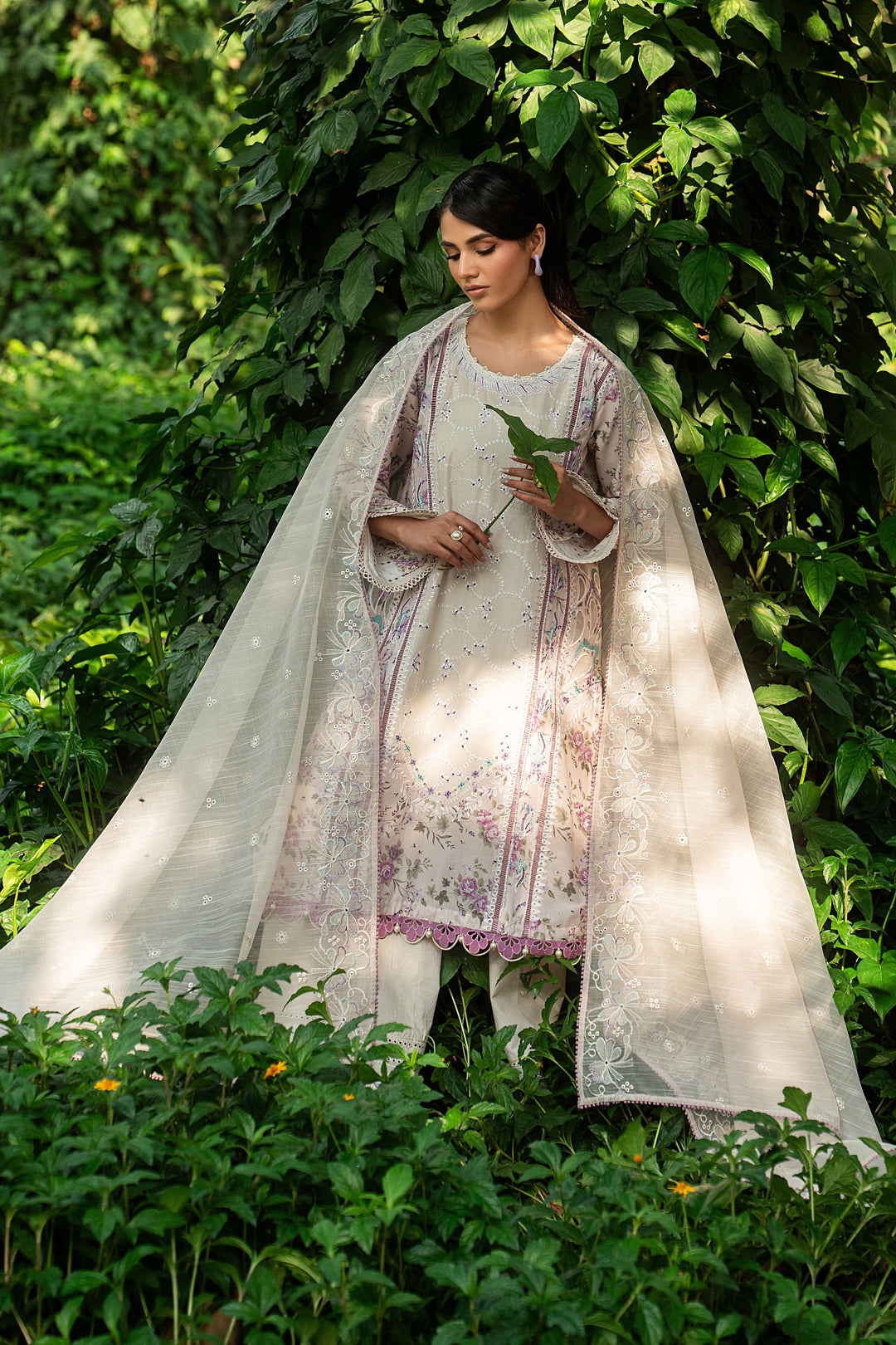 Side angle of Baseera ivory lawn dress highlighting detailed sleeve borders, lace hemline and breathable fabric for warm weather