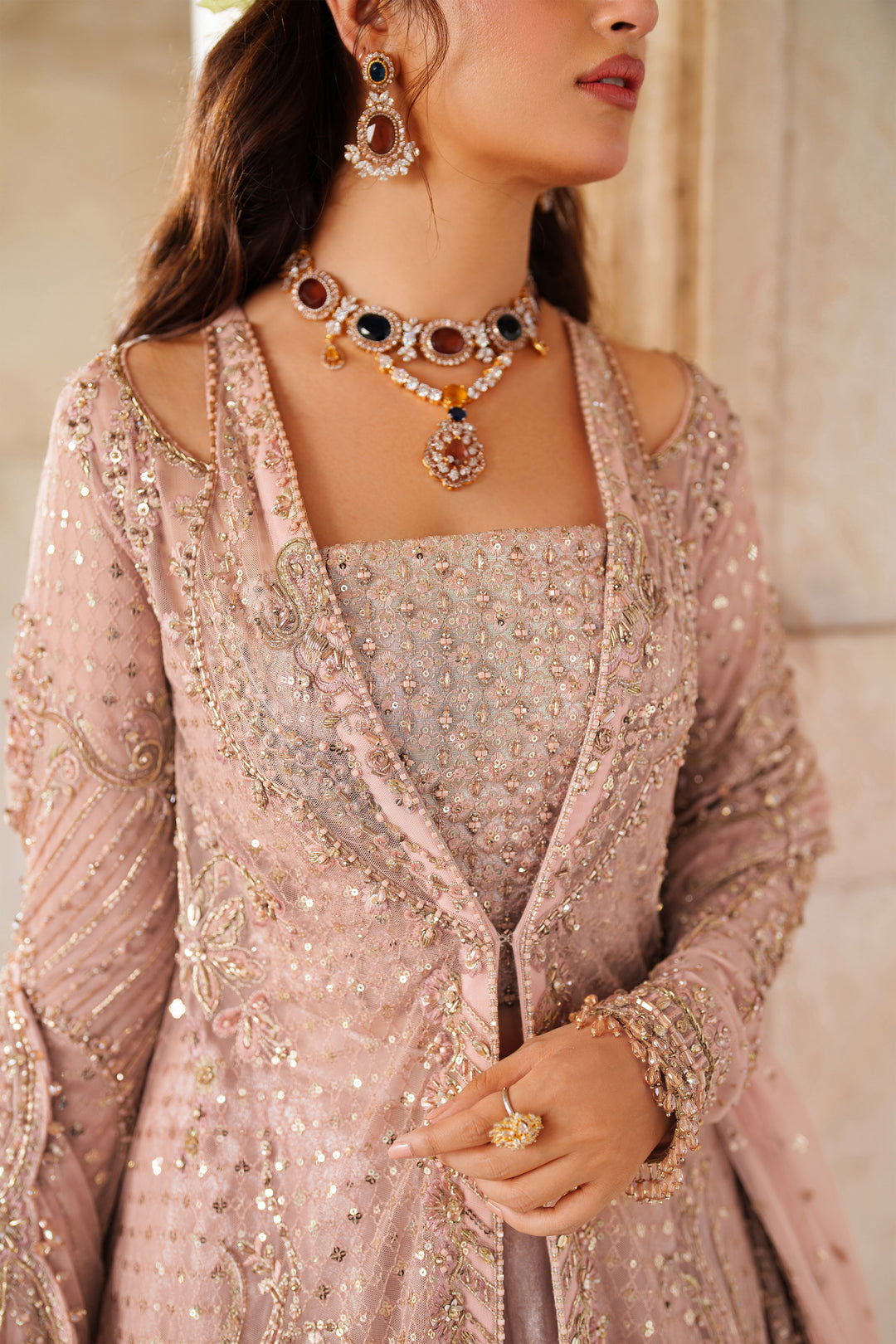 Styled close-up of NAQSHI Mareeha soft pink ready-to-wear gown featuring embroidered bodice and detailed neckline for festive events.