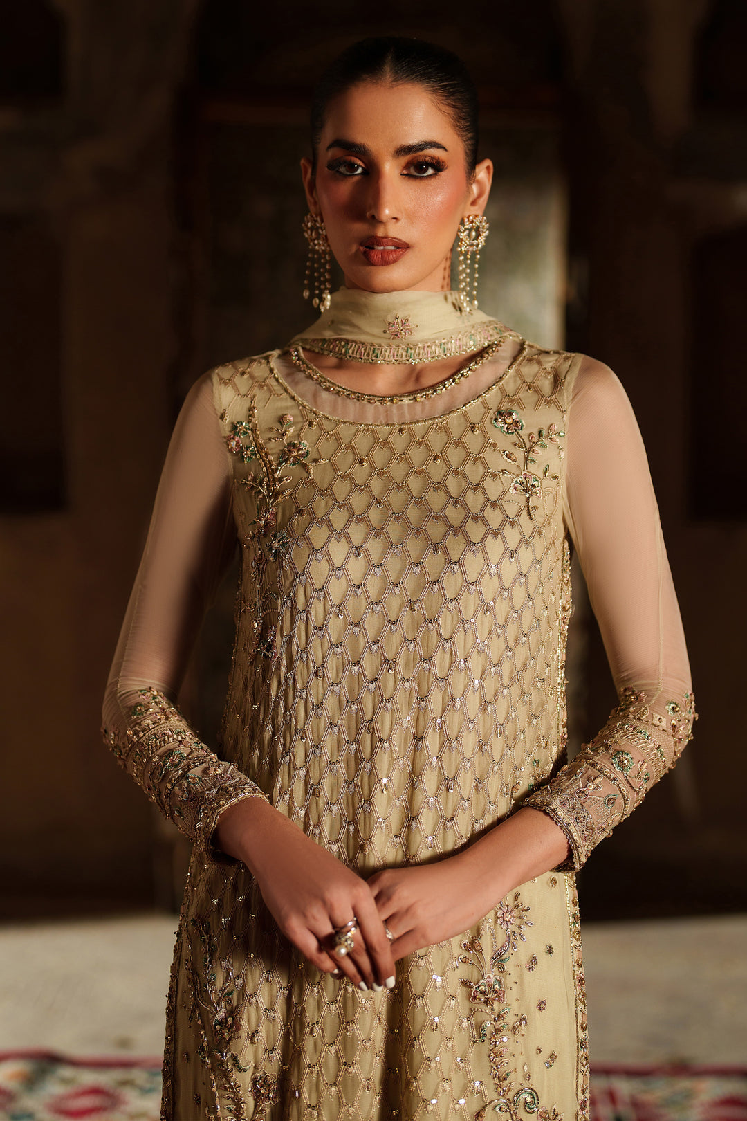 Woman wearing a beige embroidered traditional outfit with a blurred background