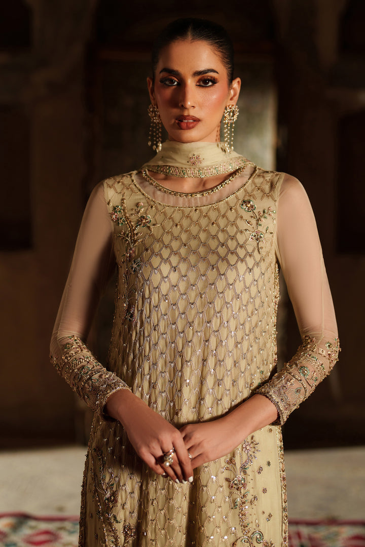 Woman wearing a beige embroidered traditional outfit with a blurred background