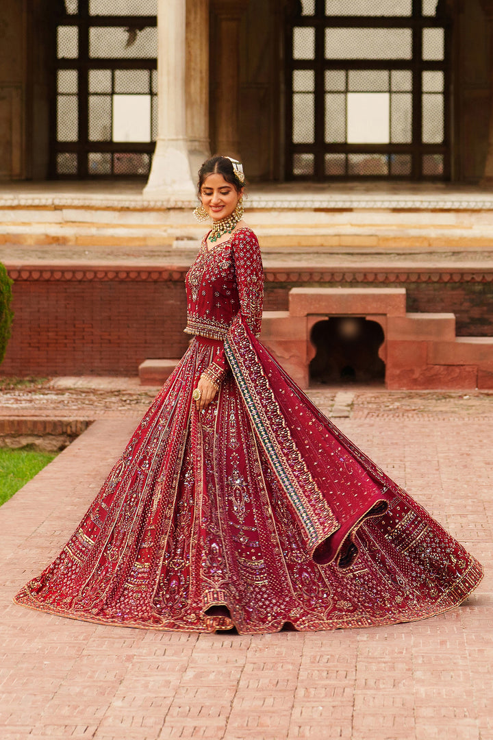 Movement shot of NAQSHI Gul Kand red bridal lehenga displaying flare and design detail on the skirt for special wedding events.
