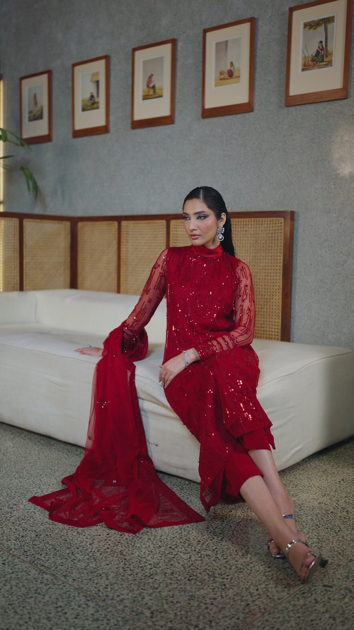 Walking view of NAQSHI Valentina rose red net ready-to-wear outfit showing light fabric movement, balanced shape, and polished event look.