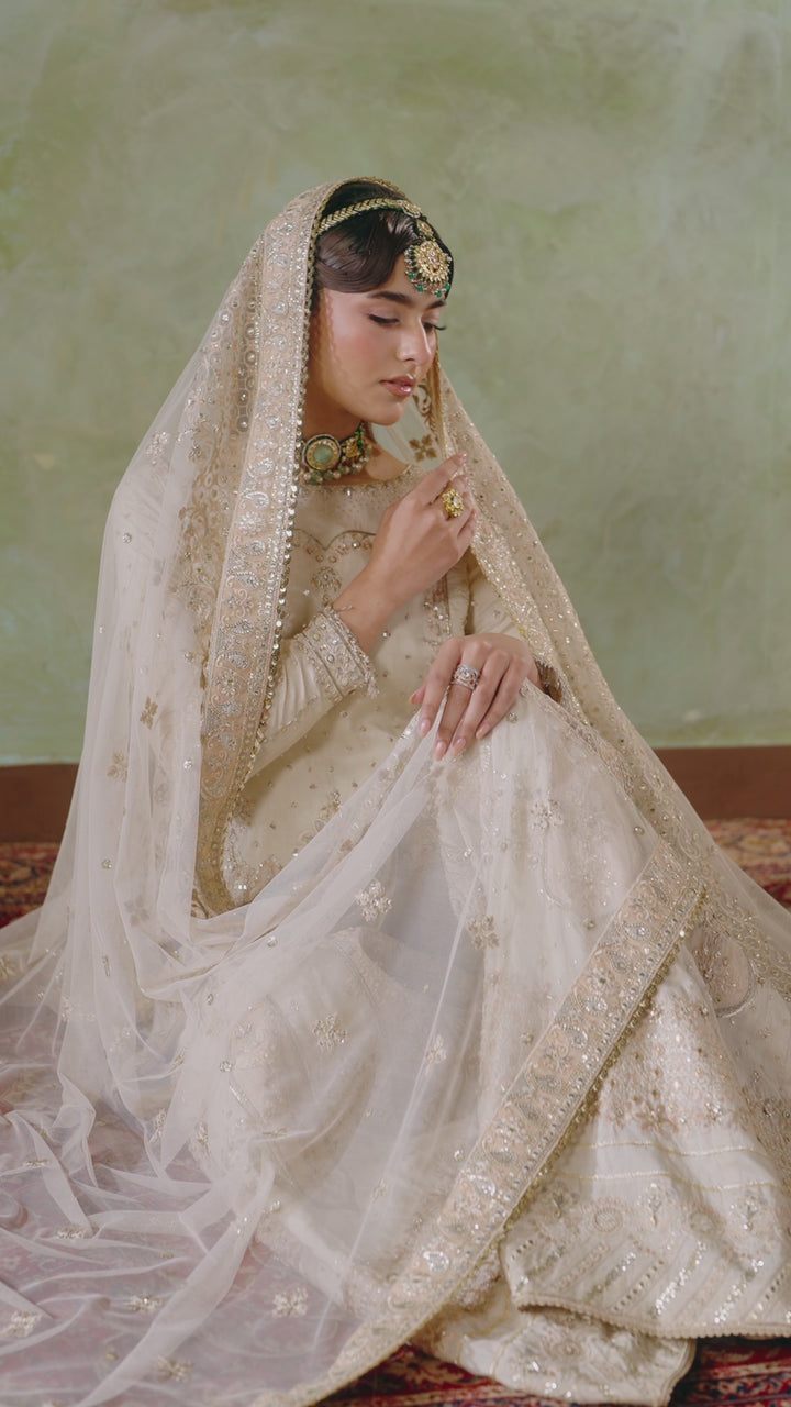 Soft bridal portrait of Damiya off white 4-piece Nikkah outfit with dupatta over head, modest elegant ready made formal bridal attire.