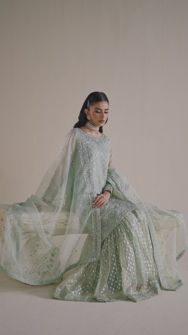 NAQSHI sage green dress shown in motion, highlighting elegant flow and polished event look