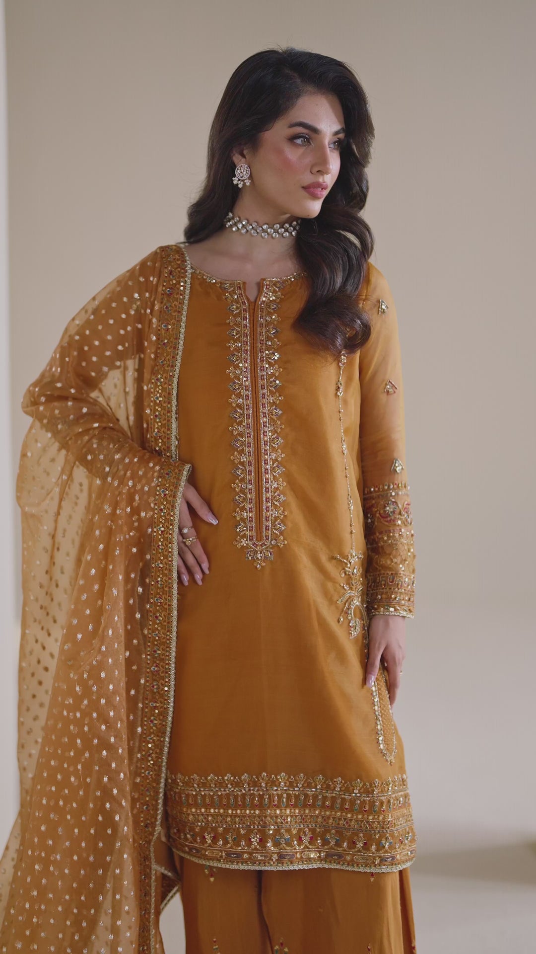NAQSHI ready-to-wear burnt orange formal dress shown in motion, displaying soft fabric flow and elegant occasion styling