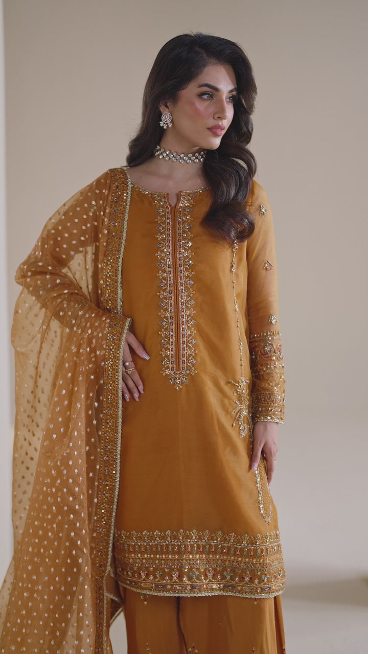 NAQSHI ready-to-wear burnt orange formal dress shown in motion, displaying soft fabric flow and elegant occasion styling
