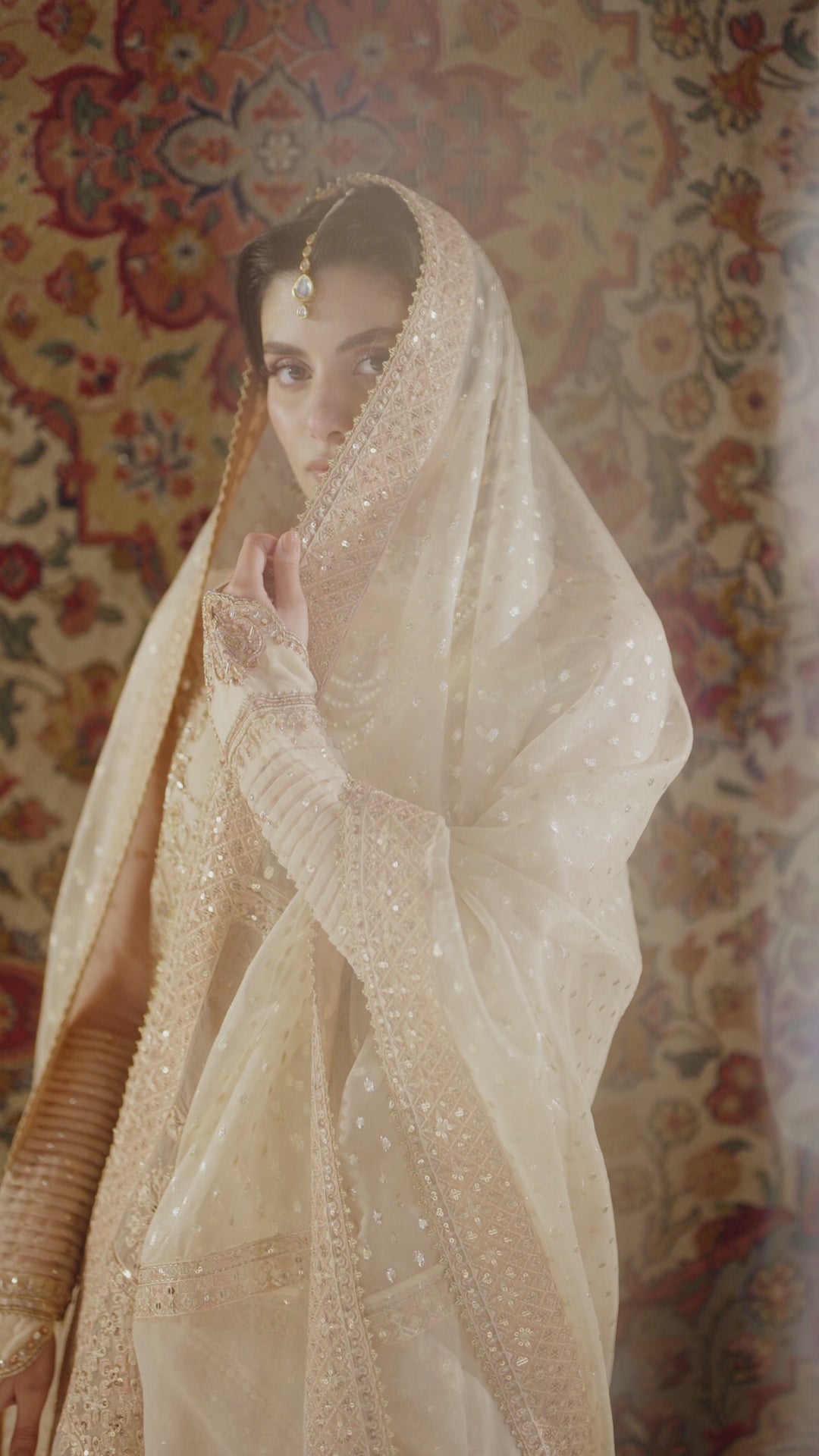 Soft bridal portrait of Tizmat peach 4-piece Nikkah outfit with sheer organza dupatta covering head, modest and calm wedding look, complete ready made formal attire.