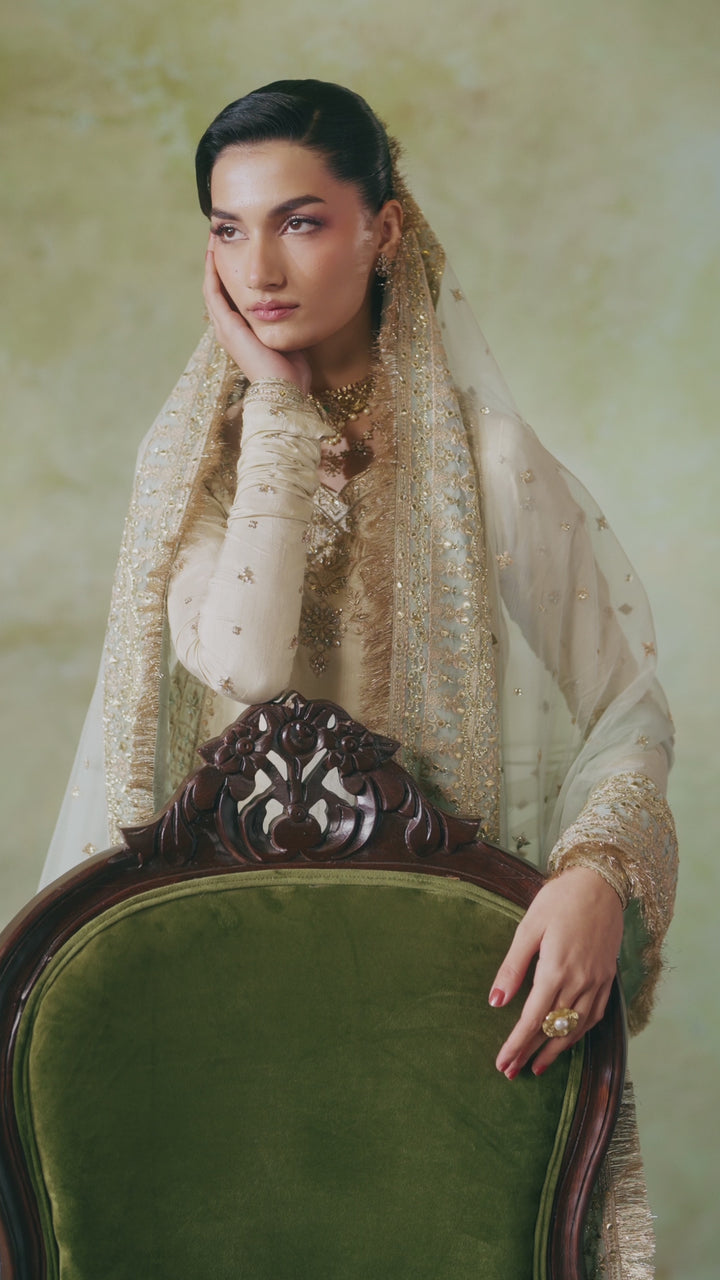 Close portrait of Zemira beige peach 4-piece Nikkah outfit with dupatta over head and detailed embroidery visible, modest formal bridal attire.