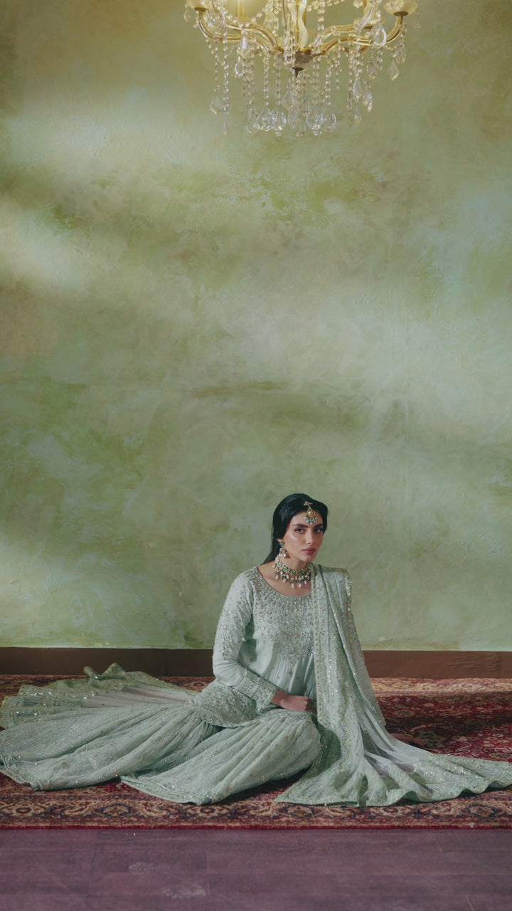 Seated bridal look of Azeyma pistachio 4-piece Nikkah outfit with spread net sharara and draped dupatta, calm and graceful ready made wedding attire.